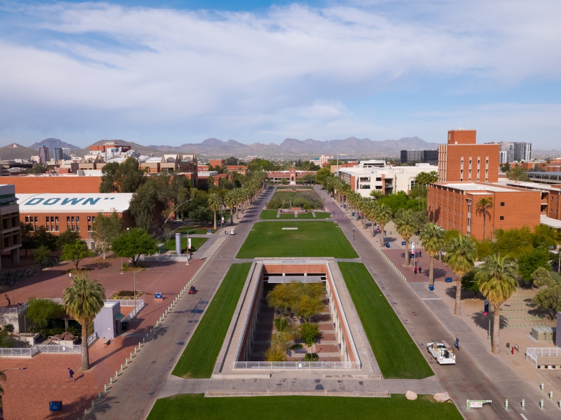 Drone view of the University of Arizona Mall, facing west from the Main Library to Old Main, with mountains in the background