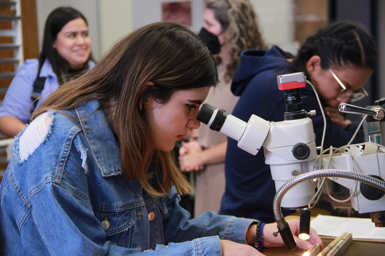 Women in STEM 2022 Tree Ring Lab - student lo9oking in a microscope