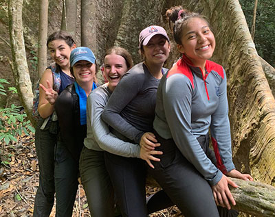 Students sitting on a log