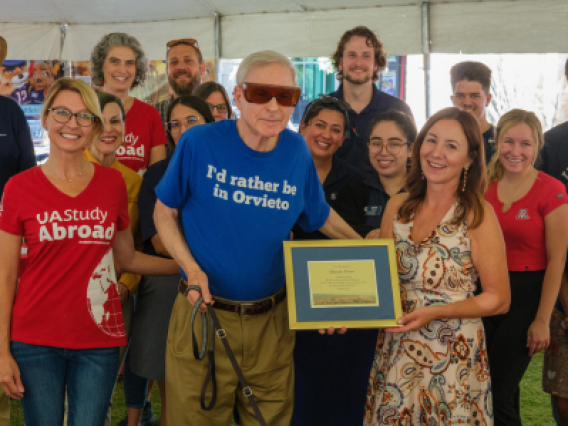 Dr. David Soren holds his plaque while standing with study abroad staff and volunteers.