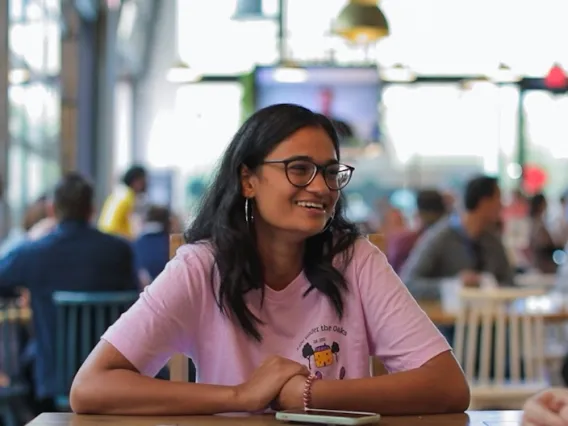 UArizona student Ananya sits at a table talking with friends.