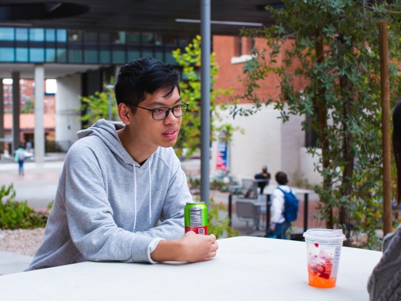 Study Arizona student Quan Minh Le sitting outside on campus.