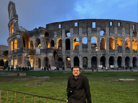 U of A student Eric in front of a colosseum. 