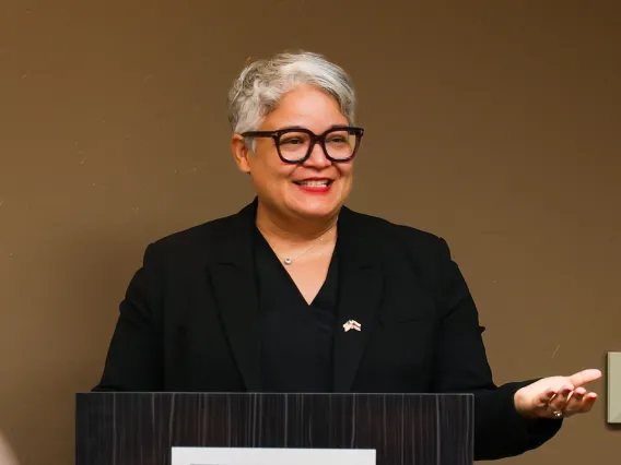 U.S. Ambassador to Oman Ana stands behind a podium 