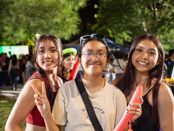 Students smiling for the camera in the Global Center courtyard.