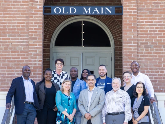 U of A and NWU leadership poses in front of Old Main.