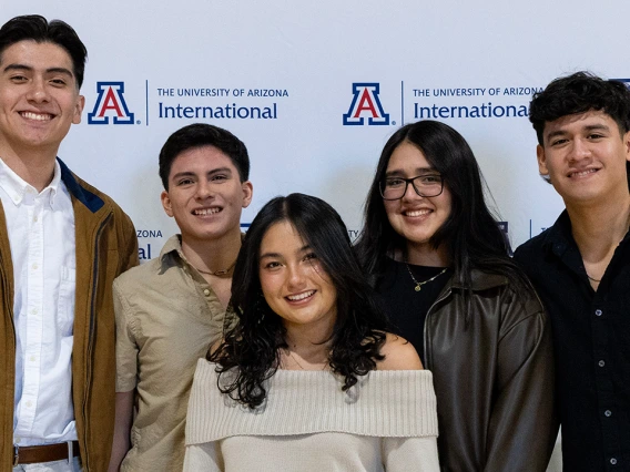 International graduates smile at the camera.