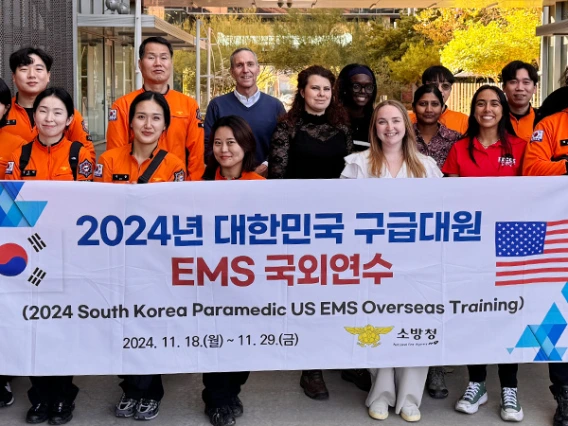 a team of firefighter paramedics from South Korea holds their banner