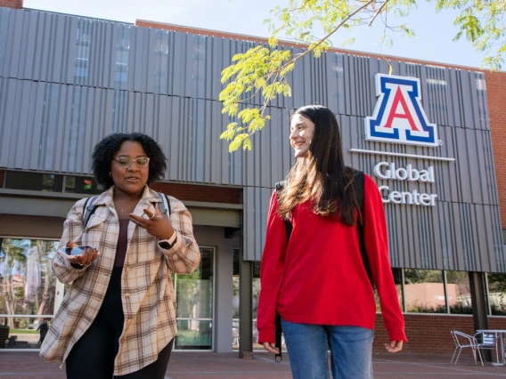 University of Arizona graduates Jennifer Gwasira, left, and Ana Lucia Velazquez Encinas chat as they leave the U of A Global Center