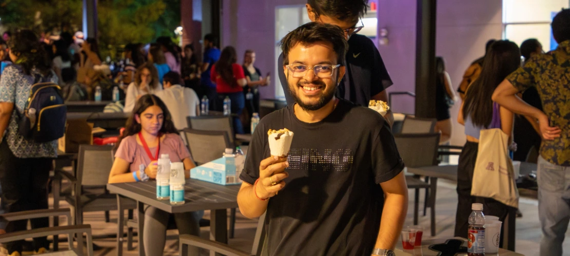 Student holding ice cream smiles at the camera