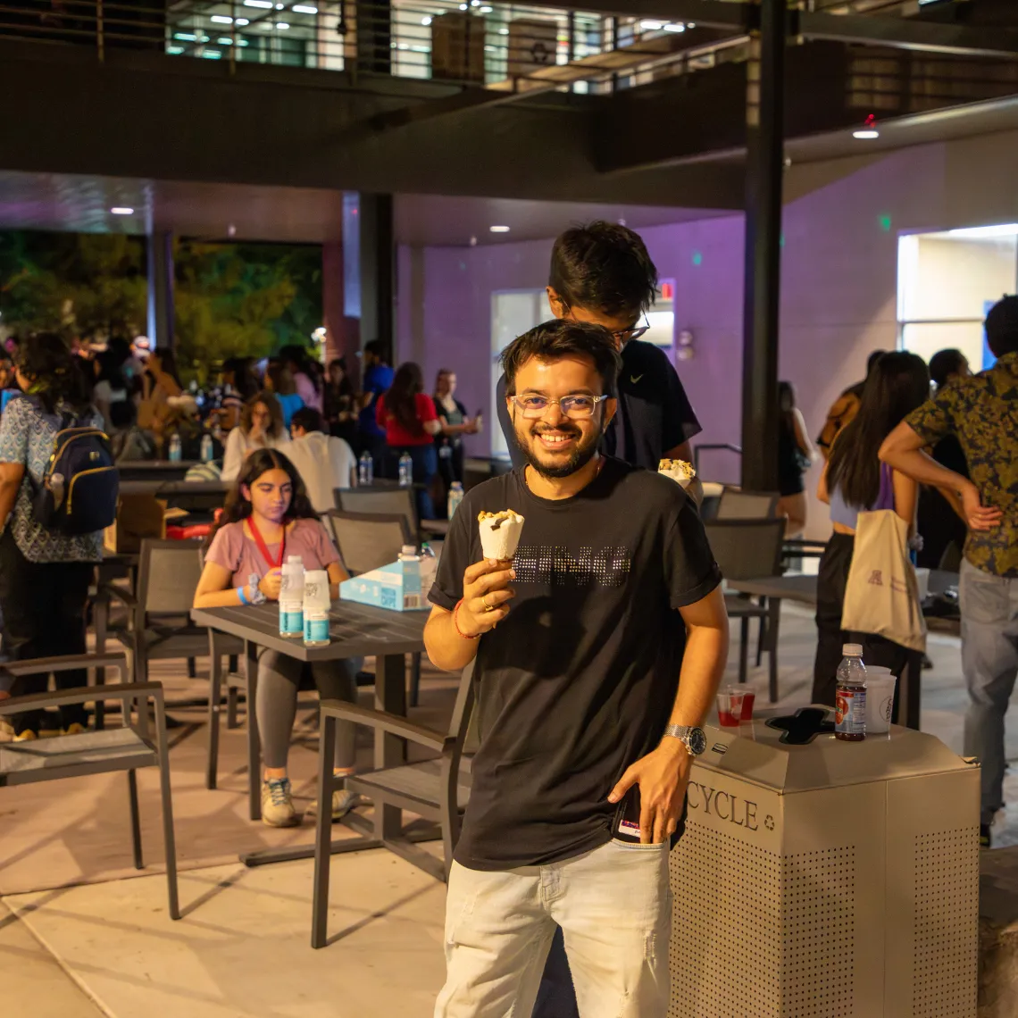 Student holding ice cream smiles at the camera