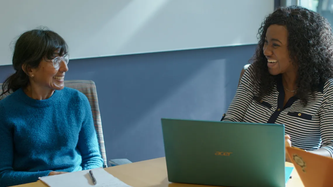 Tina, a Ph.D. student from Nigeria at the College of Public Health, laughs with a professor.