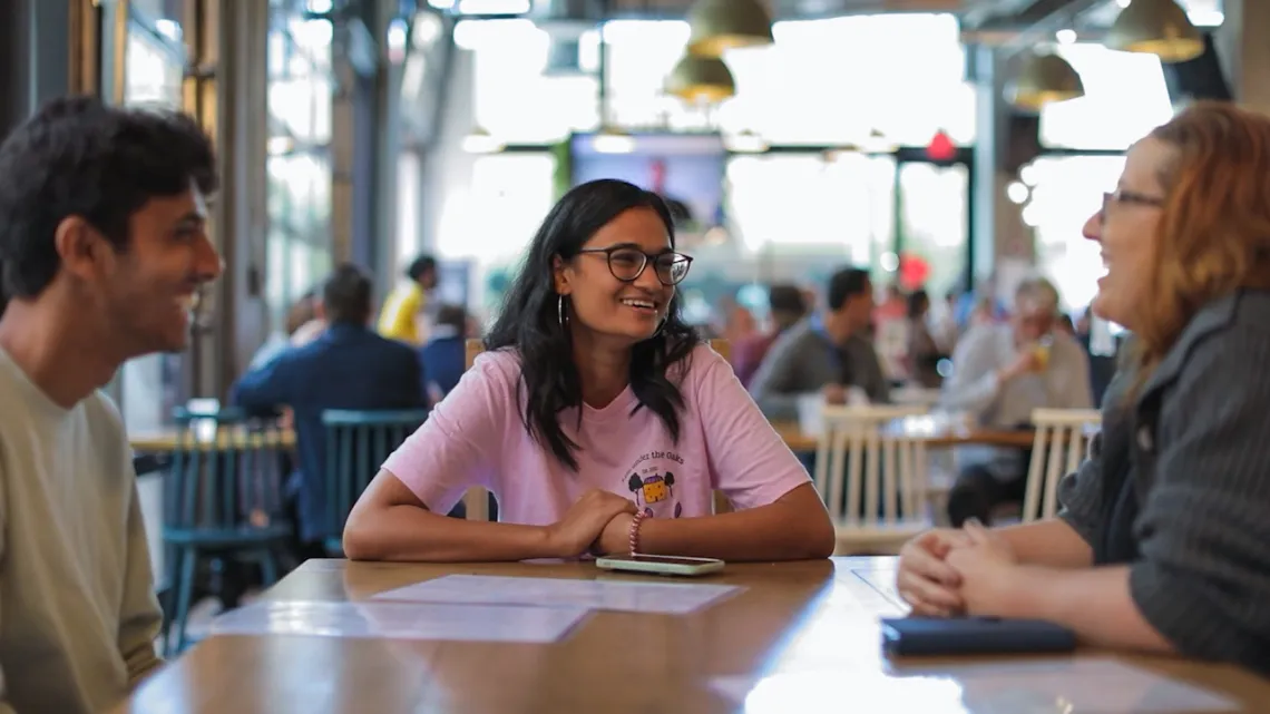 UArizona student Ananya sits at a table talking with friends.