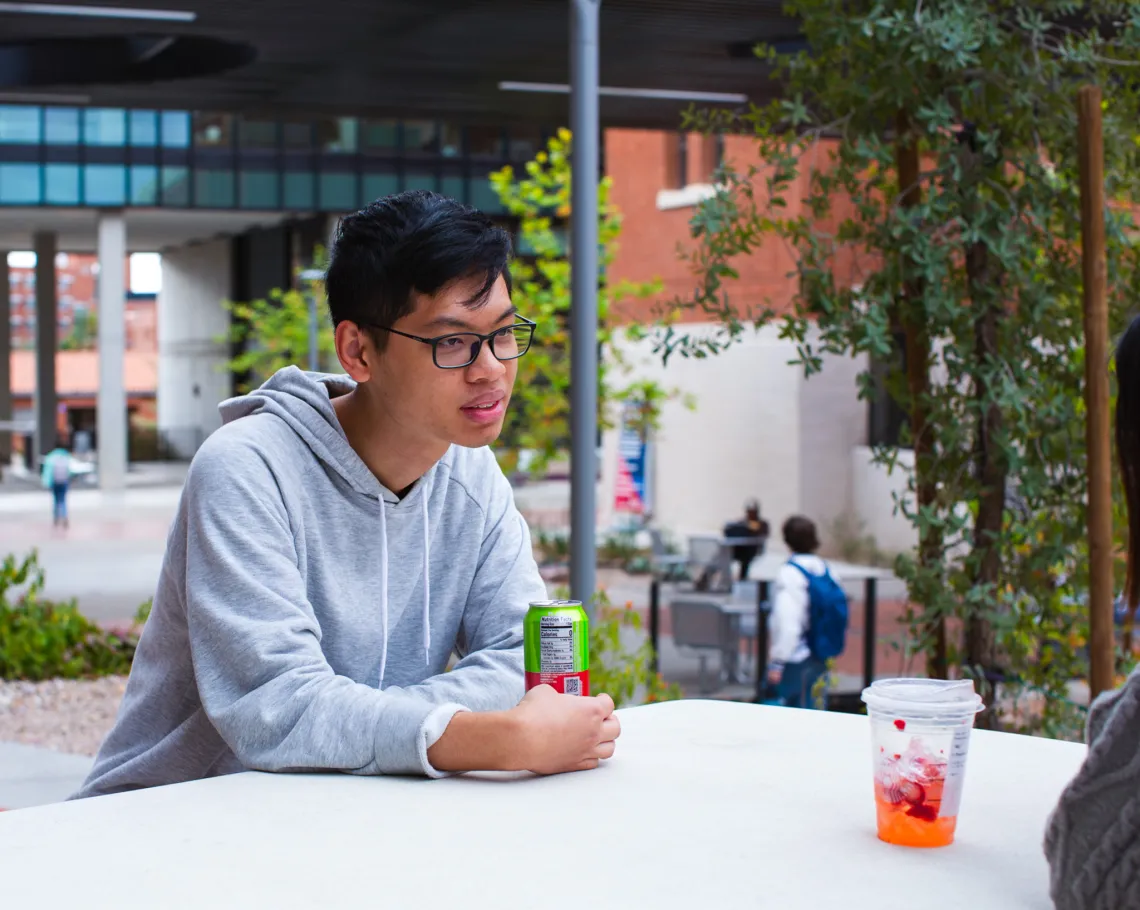 Study Arizona student Quan Minh Le sitting outside on campus.