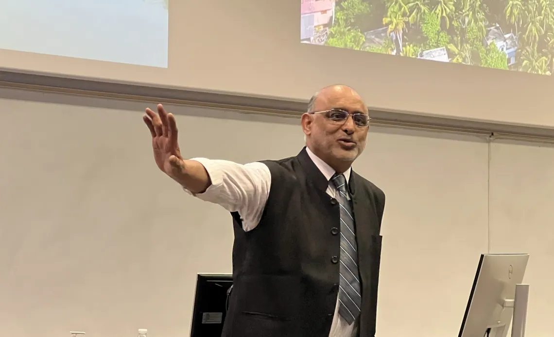 Dr. Bipin Nair in front of a presentation screen