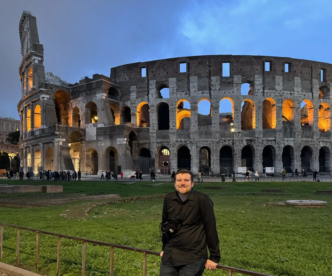 U of A student Eric in front of a colosseum. 