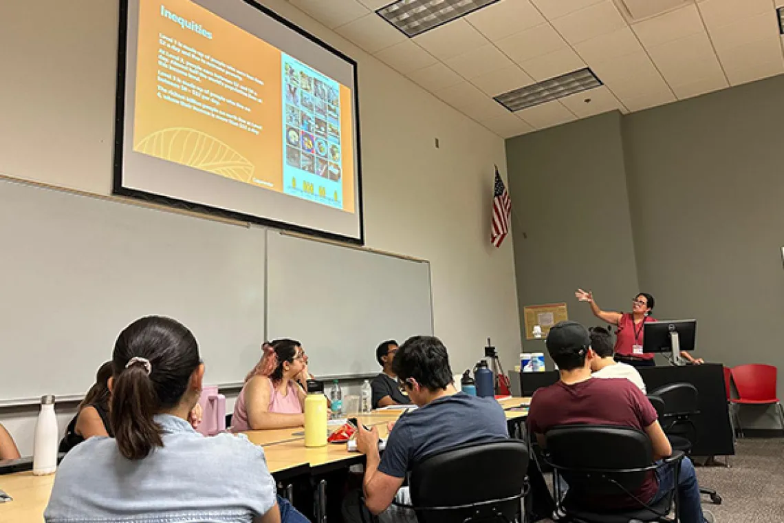 Students sit a table during a classroom presentation