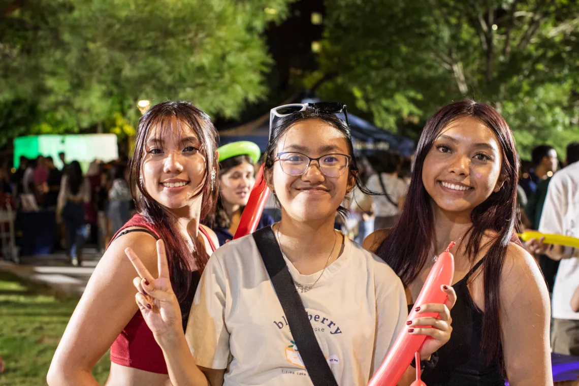 Students smiling for the camera in the Global Center courtyard.