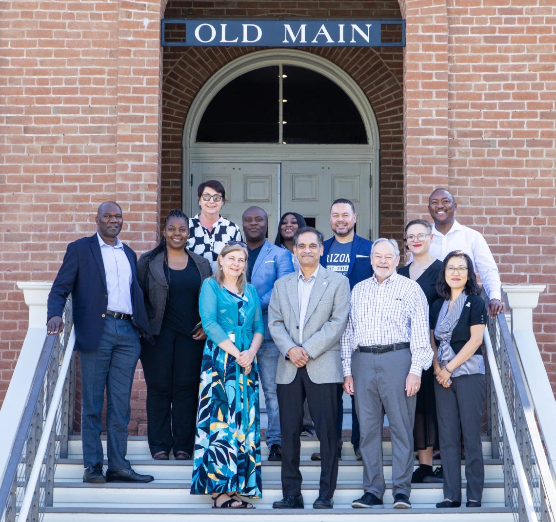 U of A and NWU leadership poses in front of Old Main.