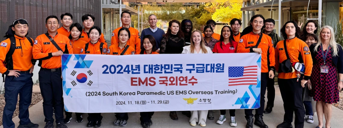 a team of firefighter paramedics from South Korea holds their banner