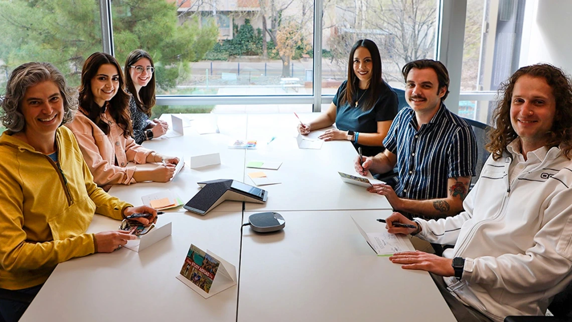 The Study Abroad team sits at a table signing thank you cards.