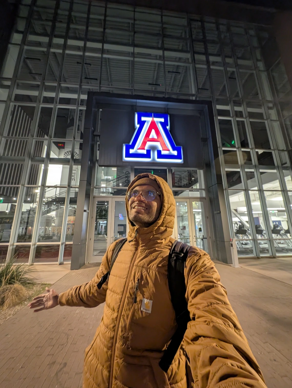 Shreyas in front of a building with a glowing block A.