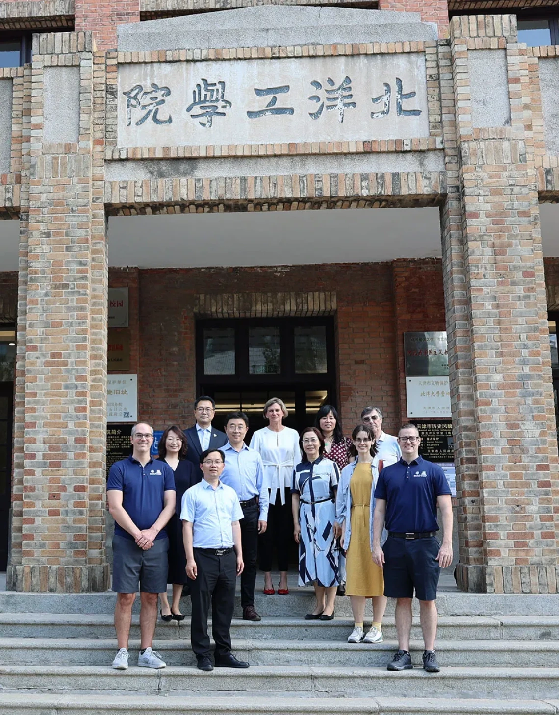 Faculty and visitors pose on stairs