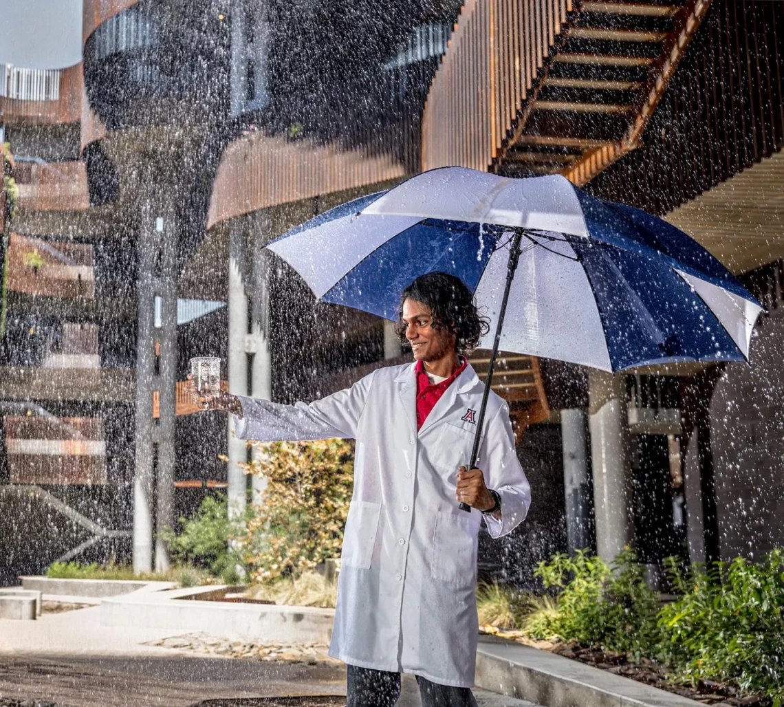 Student captures rainwater in a beaker