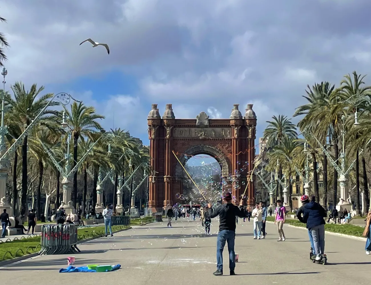 People walk along a pathway at the Arc de Triomf