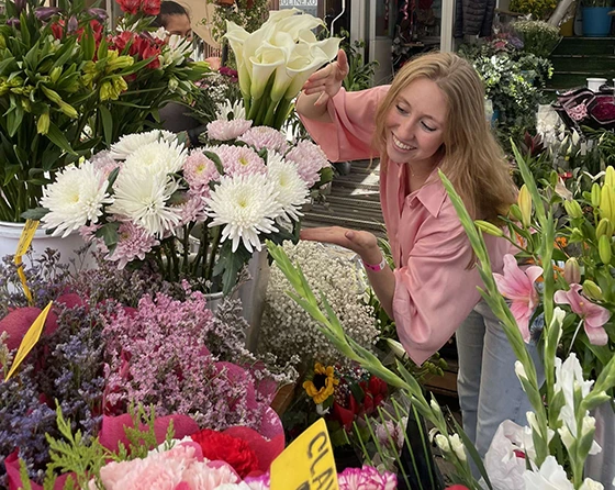 Young woman with flowers in European outdoor market