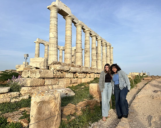 Two students standing in front of the temple of Poseidon