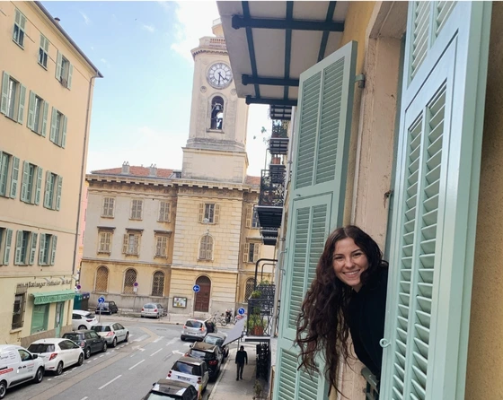 a student pops her head out a window in France