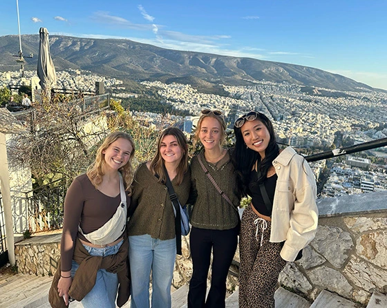 4 students stand on Lycabettus hill in Greece