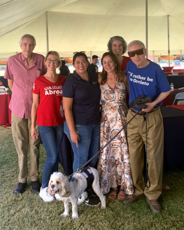 Dr. David Soren and his dog pose with study abroad staff and volunteers.