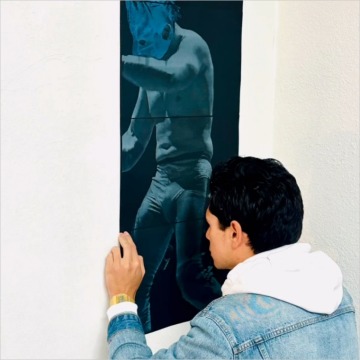 Andrés Caballero installs one of his lucha libre photos in a group exhibition at Groundworks Tucson.