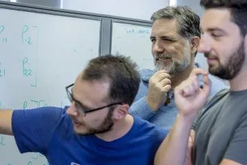 Roberto Furfaro, center, works in his lab with postdoctoral associates Andrea D'Ambrosio and Lorenzo Federici.