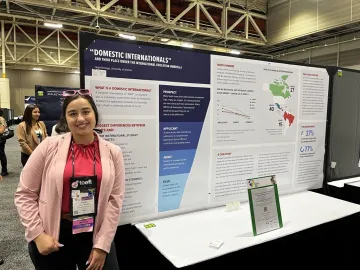 Hope stands in front of her presentation poster