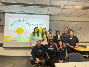 International students stand in front of a presentation screen