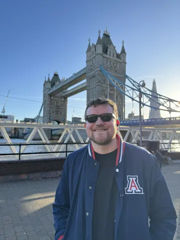 Erin in front of the London Bridge with a block A jacket.