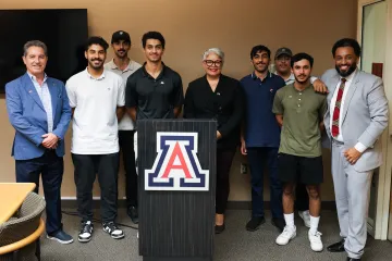 A group stands behind a block A podium.