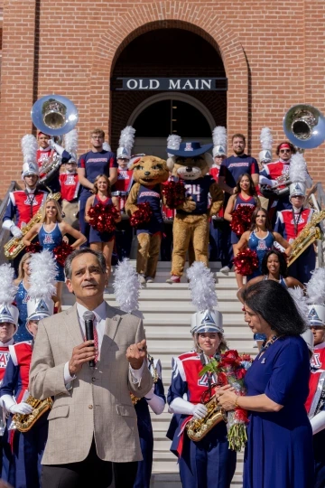 President Garimella speaks to a crowd with Old Main in the background.