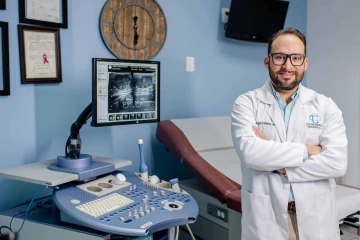 Rogelio Robles-Morales stands in front of medical equipment.