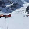 Two planes on the ground in a snowy mountain area.