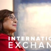 Dr. Iman Hakim, dean of the University of Arizona Mel and Enid Zuckerman College of Public Health, looks thoughtful while gazing upward. She is wearing glasses and a red outfit, with the words "International Exchange" displayed in bold white text beside her.