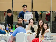 Event attendees sit at a table and enjoy the festivities.