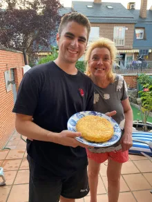 Aaron stands next to his host mom with a plate of food.