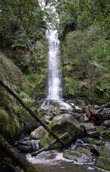 A waterfall surrounded by rocks and trees.