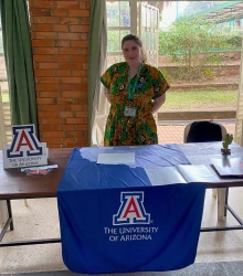 Michelle stands behind a U of A information table