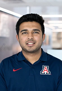 Shashwat, a Global Ambassador at the University of Arizona, wearing a navy blue Arizona polo shirt, smiles for a professional portrait.