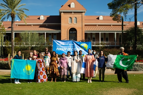 group photo of students dressed in traditional clothing, standing in front of Old Main, UA campus